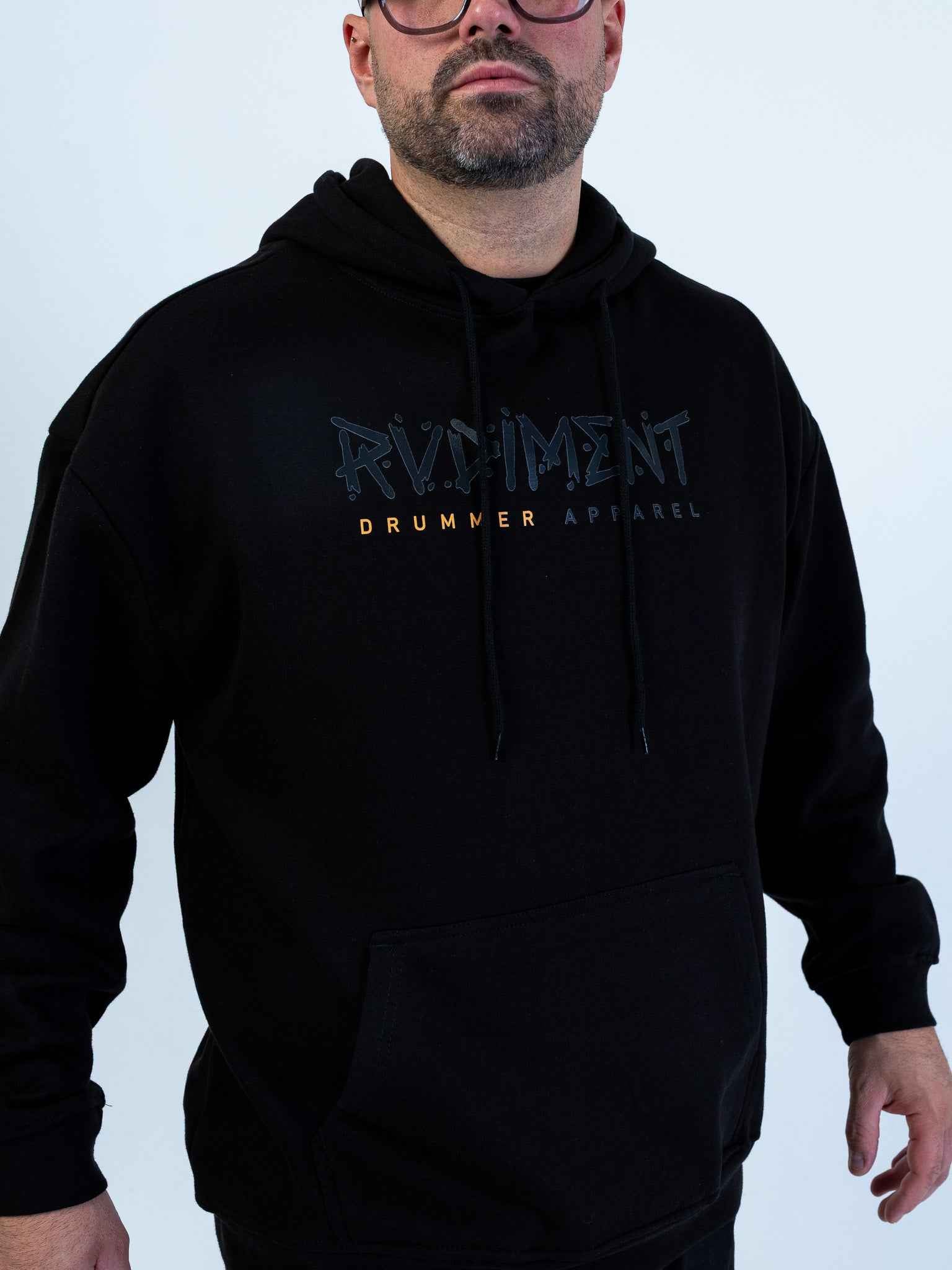 Classic Logo Hoodie for Drummers - Oversized Unisex Fit - Model Front View Close-Up | RVDIMENT Drummer Apparel